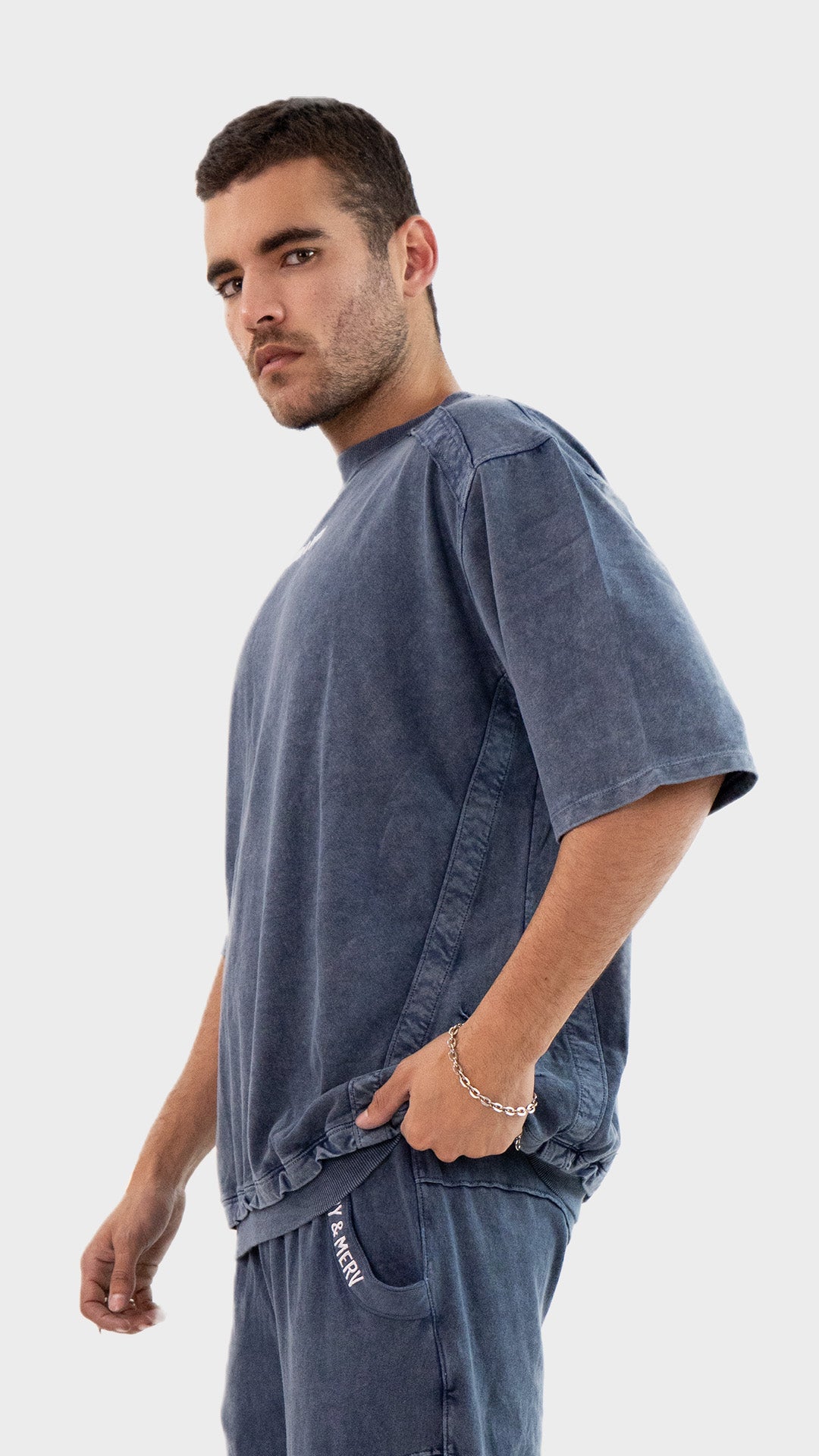 Side angle view of the Incroy and Merv Beyond T-Shirt showcasing relaxed half sleeves and ribbed hem details.
