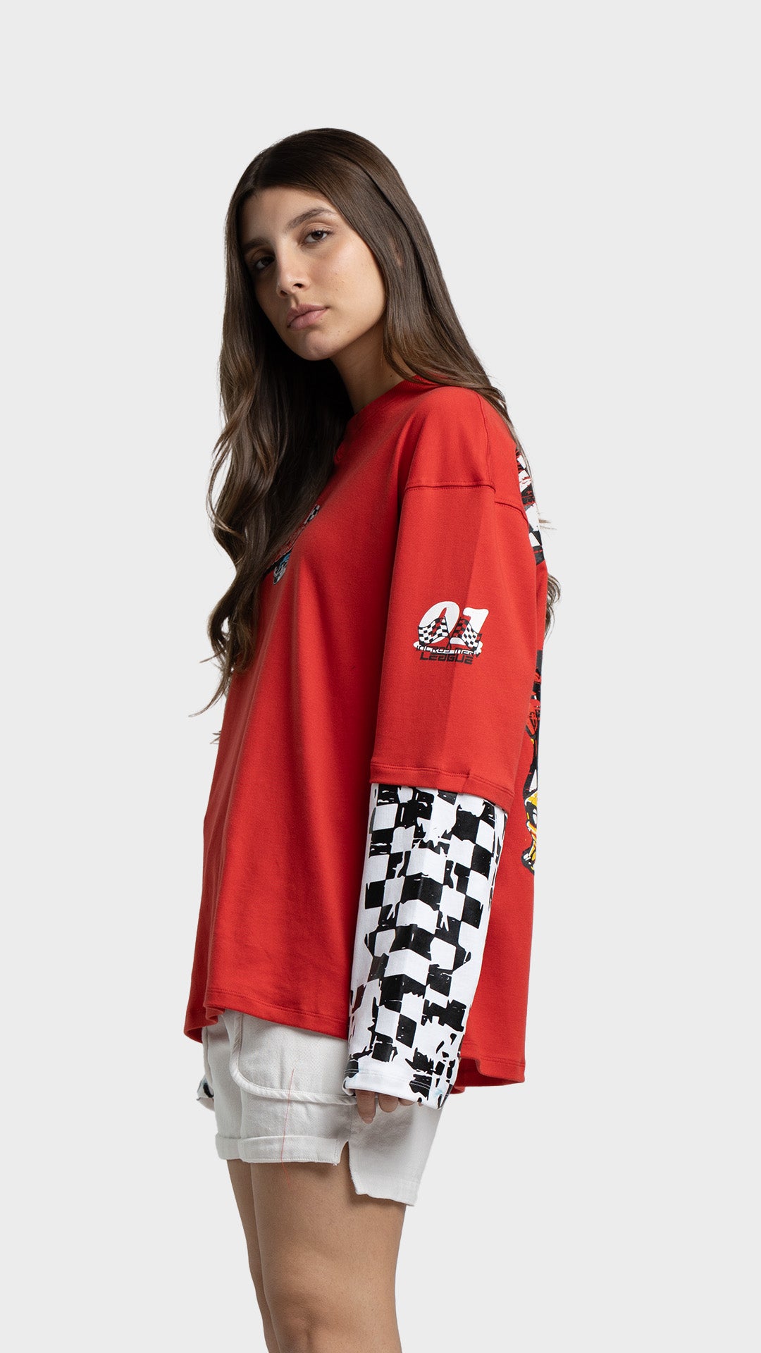 Profile angle of a red long sleeve racing t-shirt by Incroy & Merv with checkered pattern sleeves.