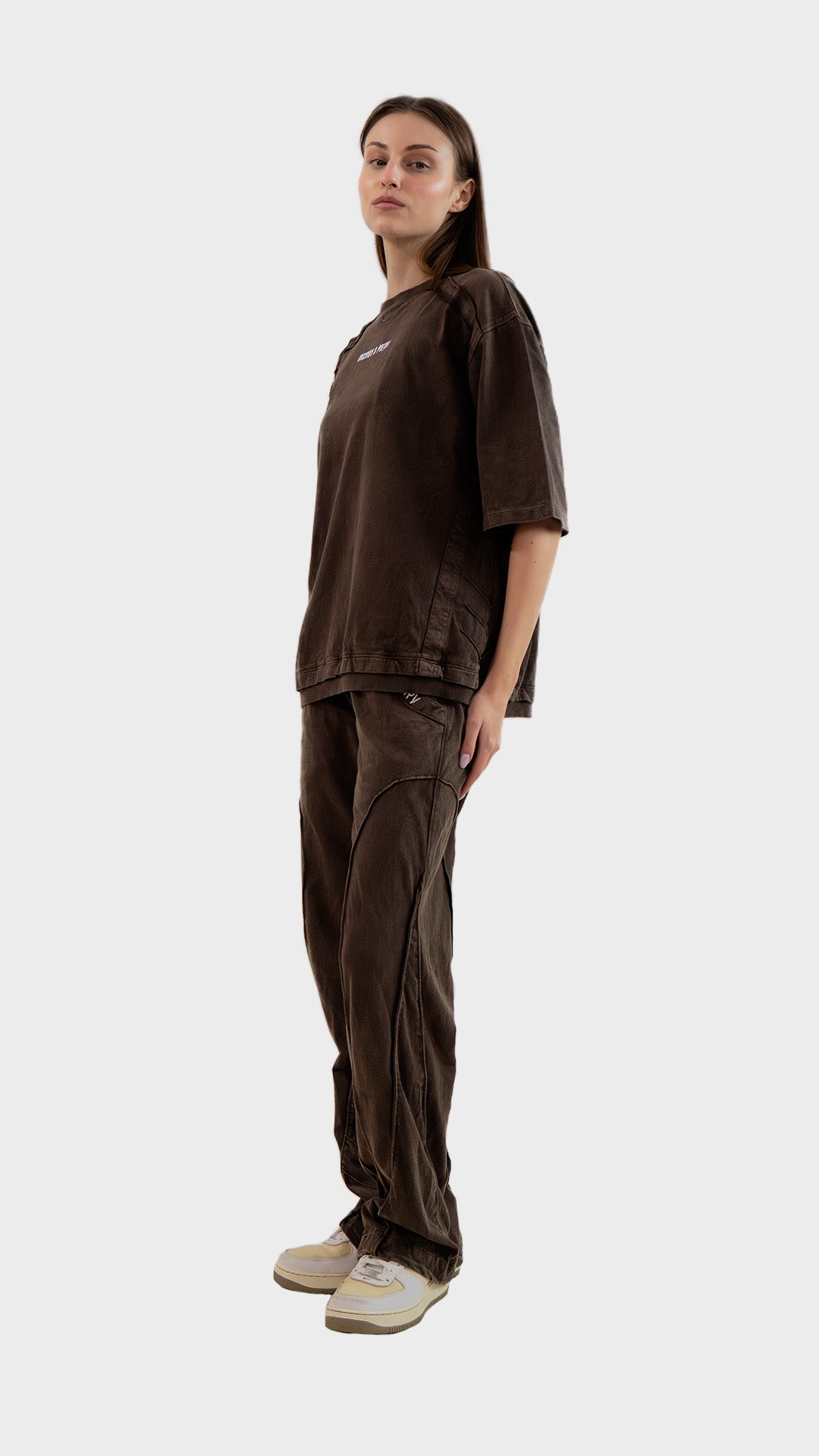 Side profile view showing the relaxed straight fit and seam paneling of Incroy & Merv women's brown cotton sinker lower.