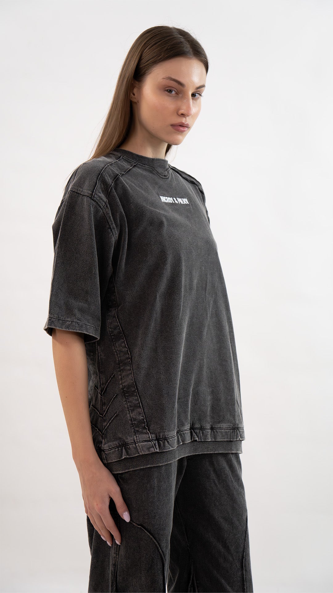 Side profile view highlighting sleeve cut and side seam stitching on the Incroy & Merv women's charcoal Beyond T-Shirt.