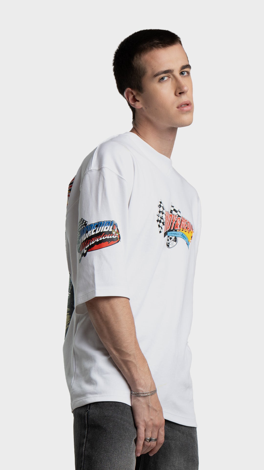 Right side profile showing the relaxed fit sleeve graphic on a white oversized tee.