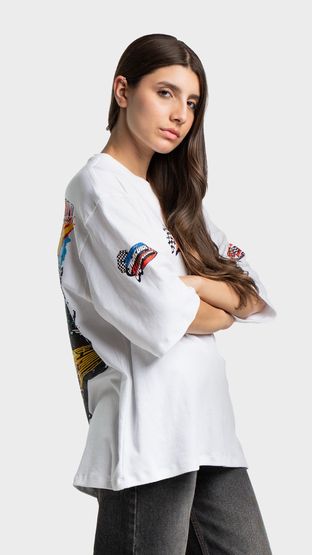 Side profile of a woman wearing a white loose-fit t-shirt with half sleeve print details.