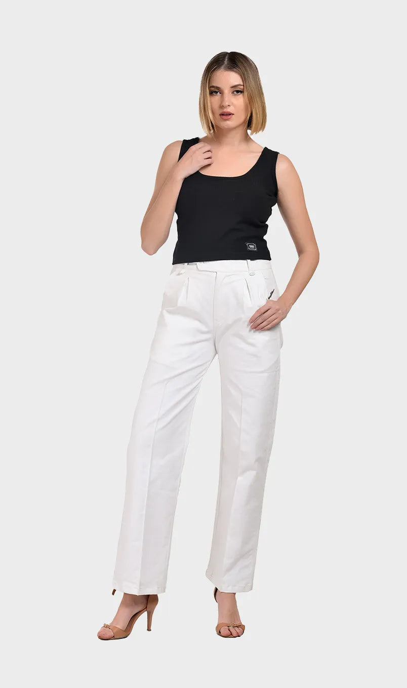 Full-body shot of a model wearing a black Parker ribbed tank top paired with high-waisted white pants and heels.