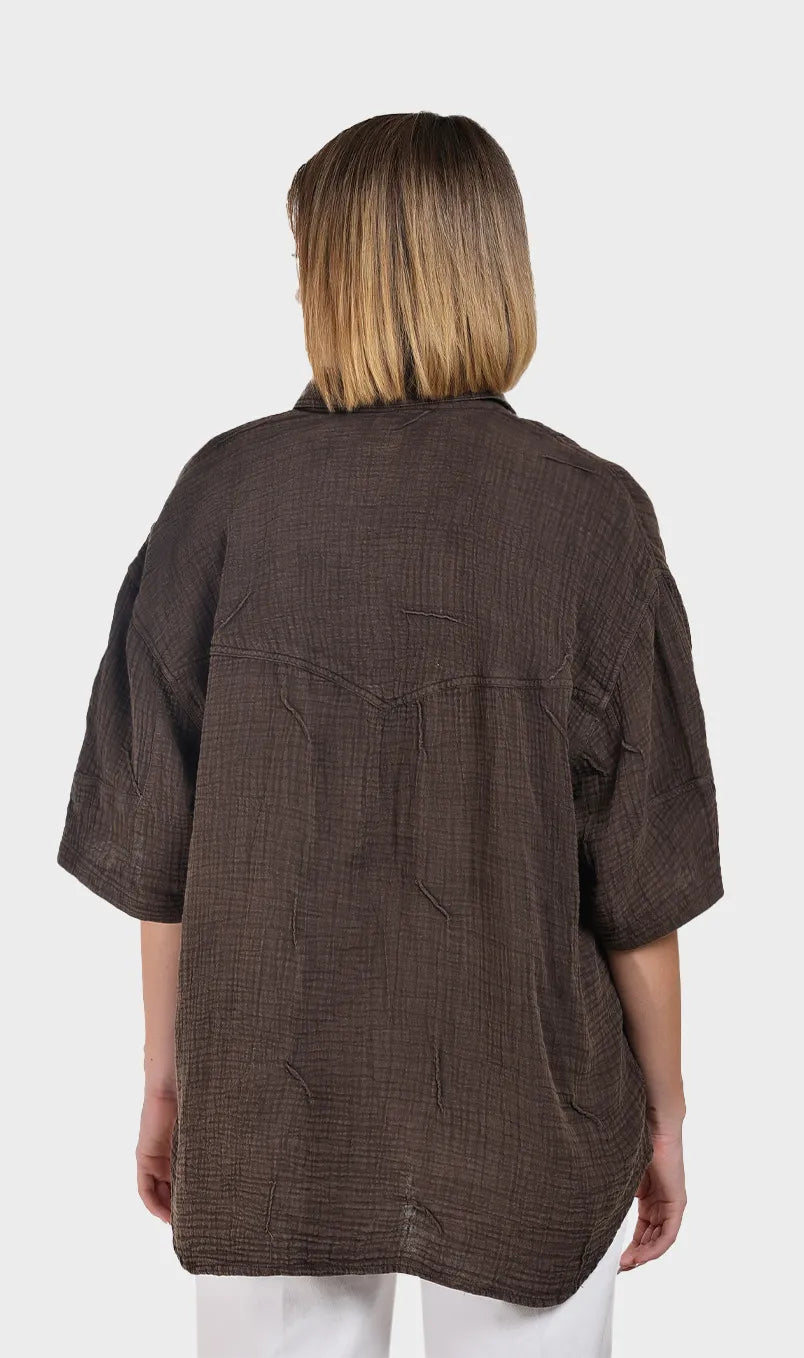 Direct back view showcasing the relaxed fit, back yoke, and crinkled texture of a women's brown 100% cotton double cloth shirt.