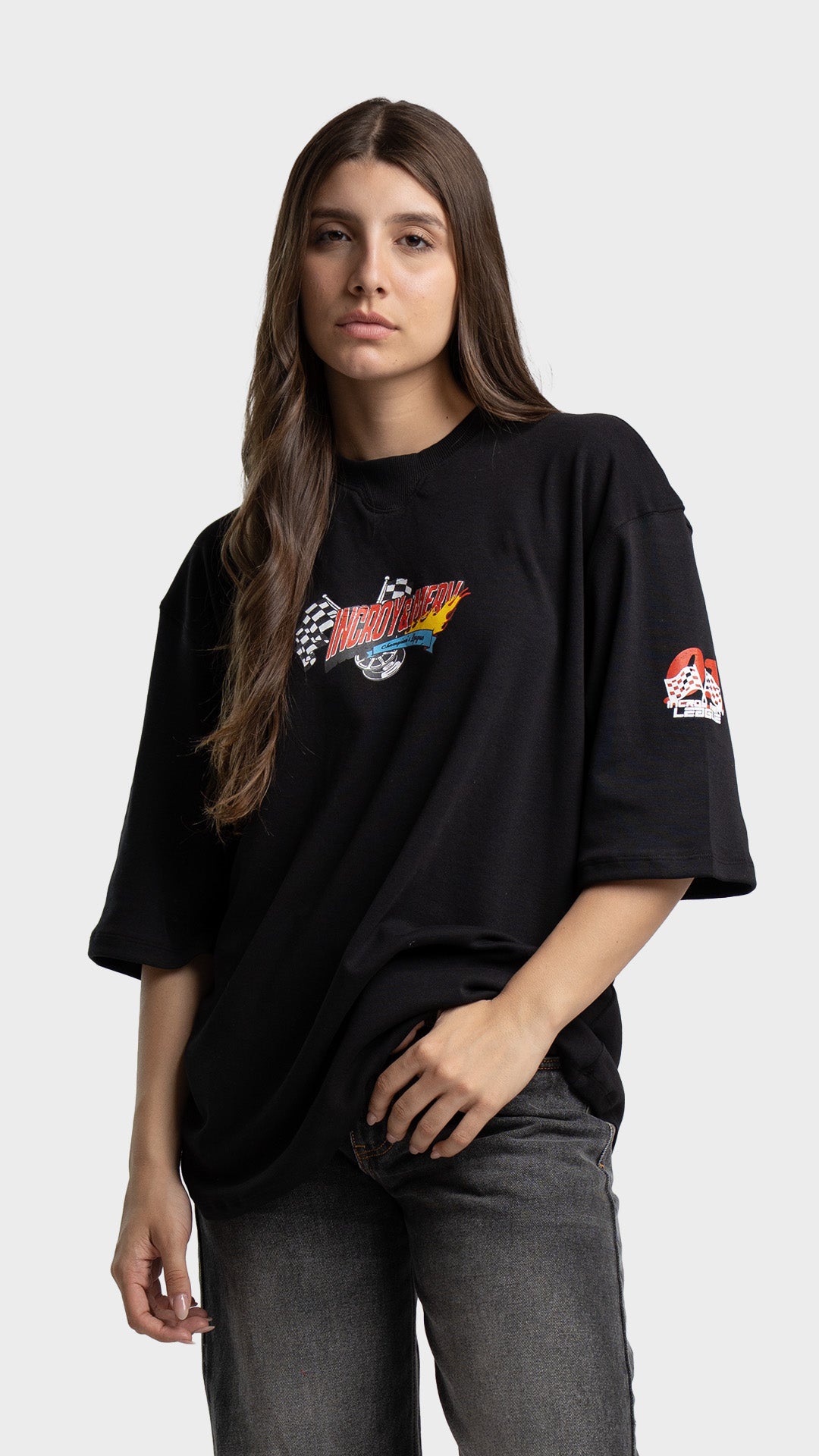 Woman wearing a black oversized streetwear t-shirt with a small retro chest graphic.