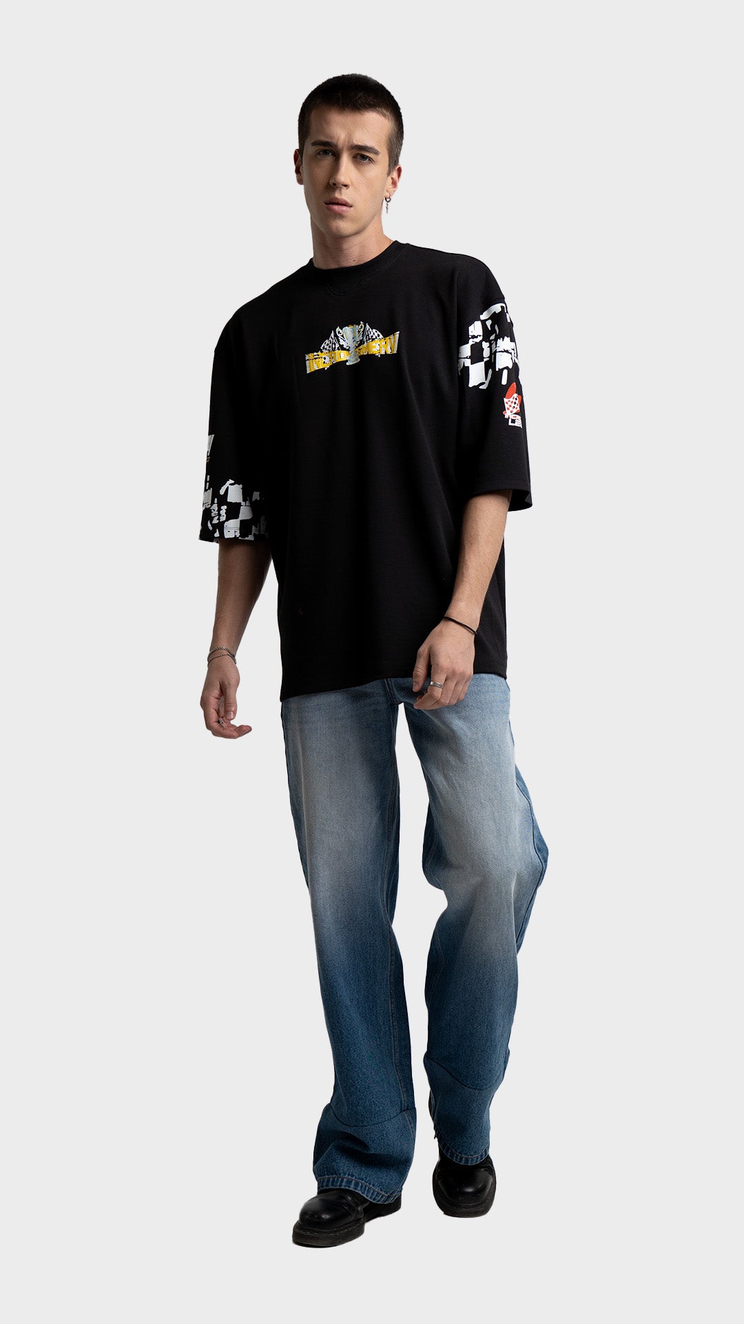 Black racing graphic tee outfit for men. Incroy & Merv mediumweight summer streetwear t-shirt styled with baggy light blue jeans.