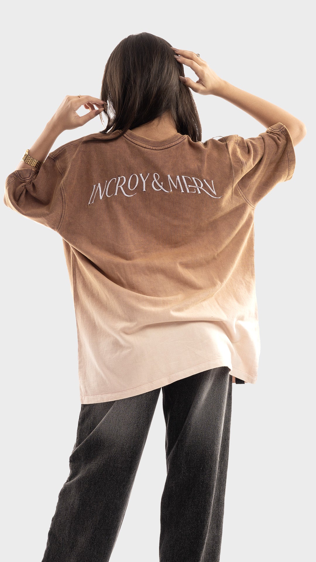 Back view of a brown gradient oversized t-shirt with embroidered back lettering.