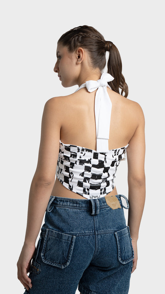 Back view of a white backless halter top with a black and white checkered flag print and neck tie.