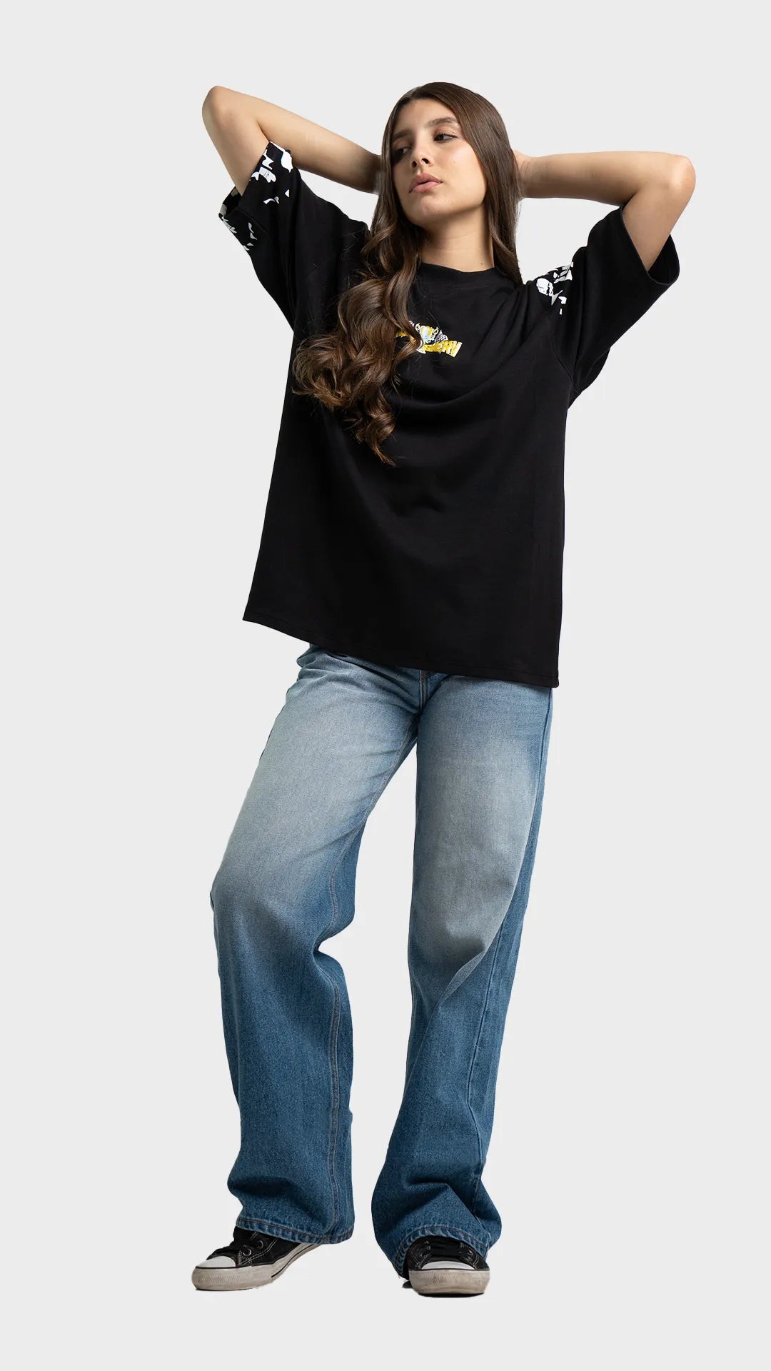 Heavyweight cotton streetwear t-shirt. Loose oversized black graphic tee styled with baggy blue jeans.