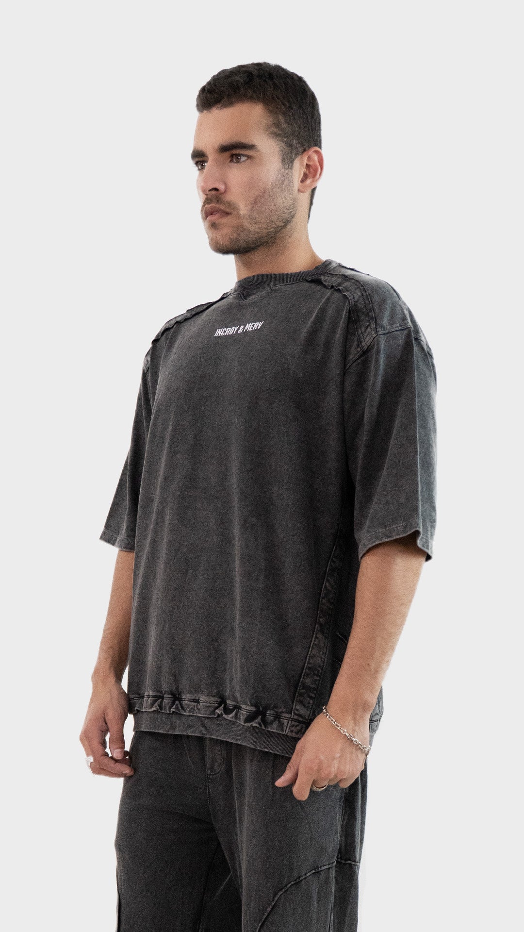 Three quarter side view of the Incroy and Merv Charcoal Beyond T-Shirt highlighting the relaxed fit and ribbed hem.