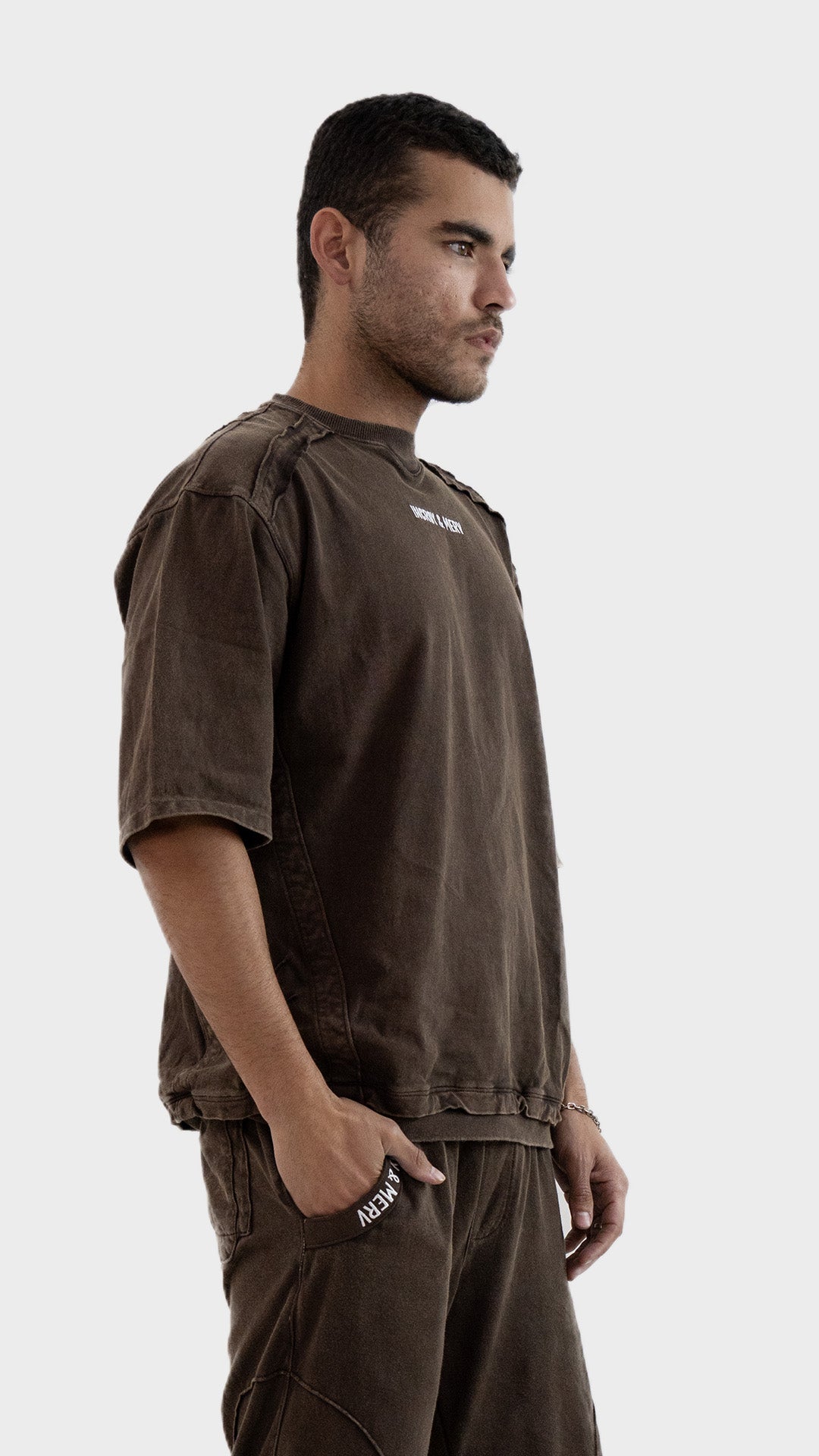 Three quarter angle view of the Incroy and Merv Rustic Brown Beyond T-Shirt showing half sleeves and ribbed hem details.