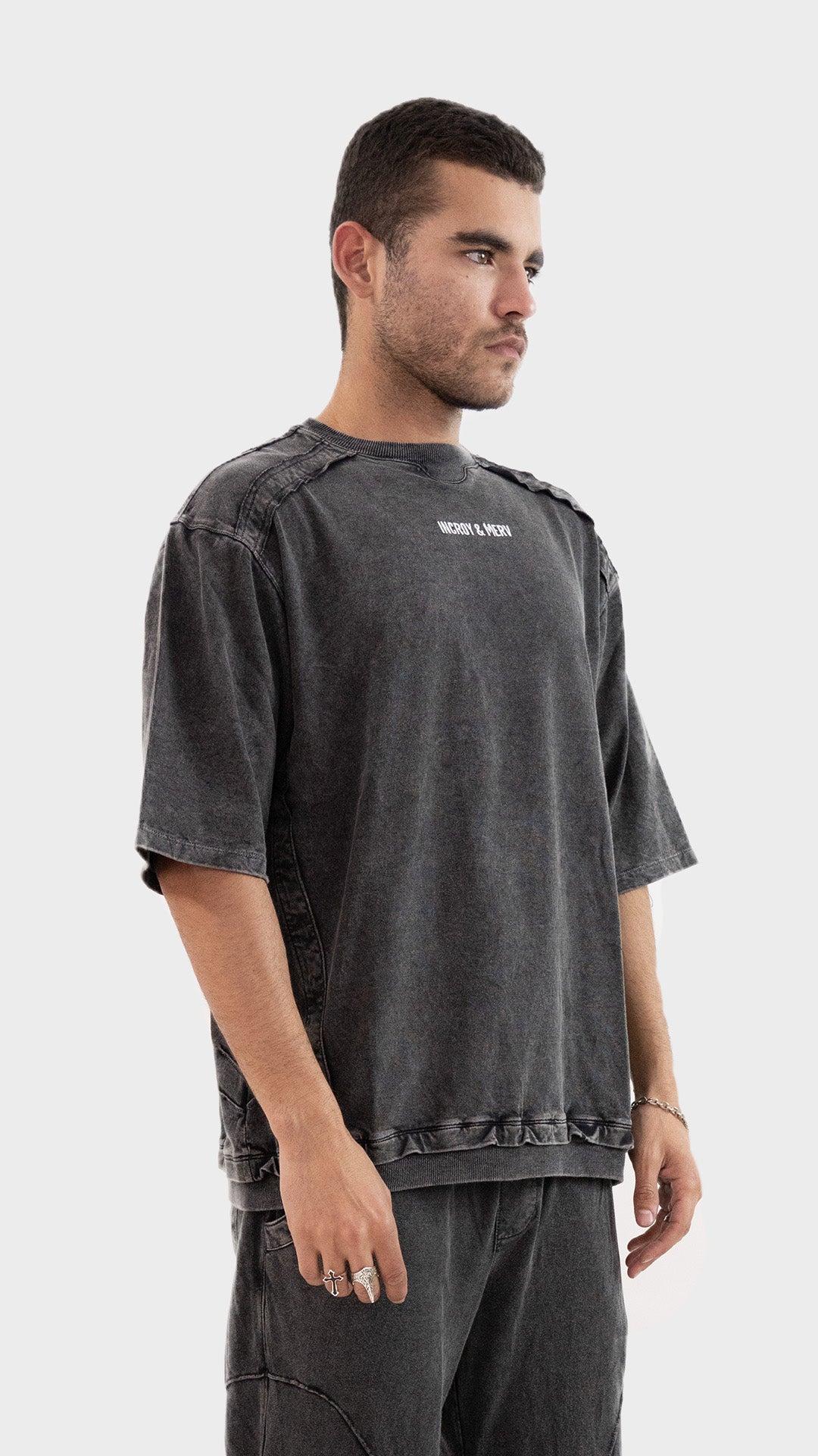 Profile side view of the Incroy and Merv Beyond T-Shirt in Charcoal showcasing drop shoulder streetwear styling.