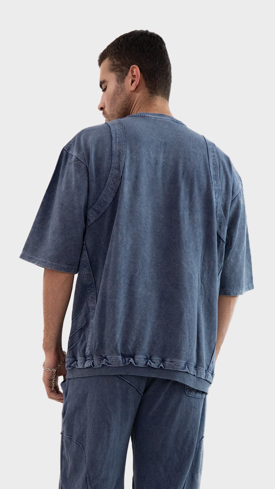 Back view of the Incroy and Merv Dusky Blue Beyond T-Shirt showing vintage wash finish and exposed seam stitching.