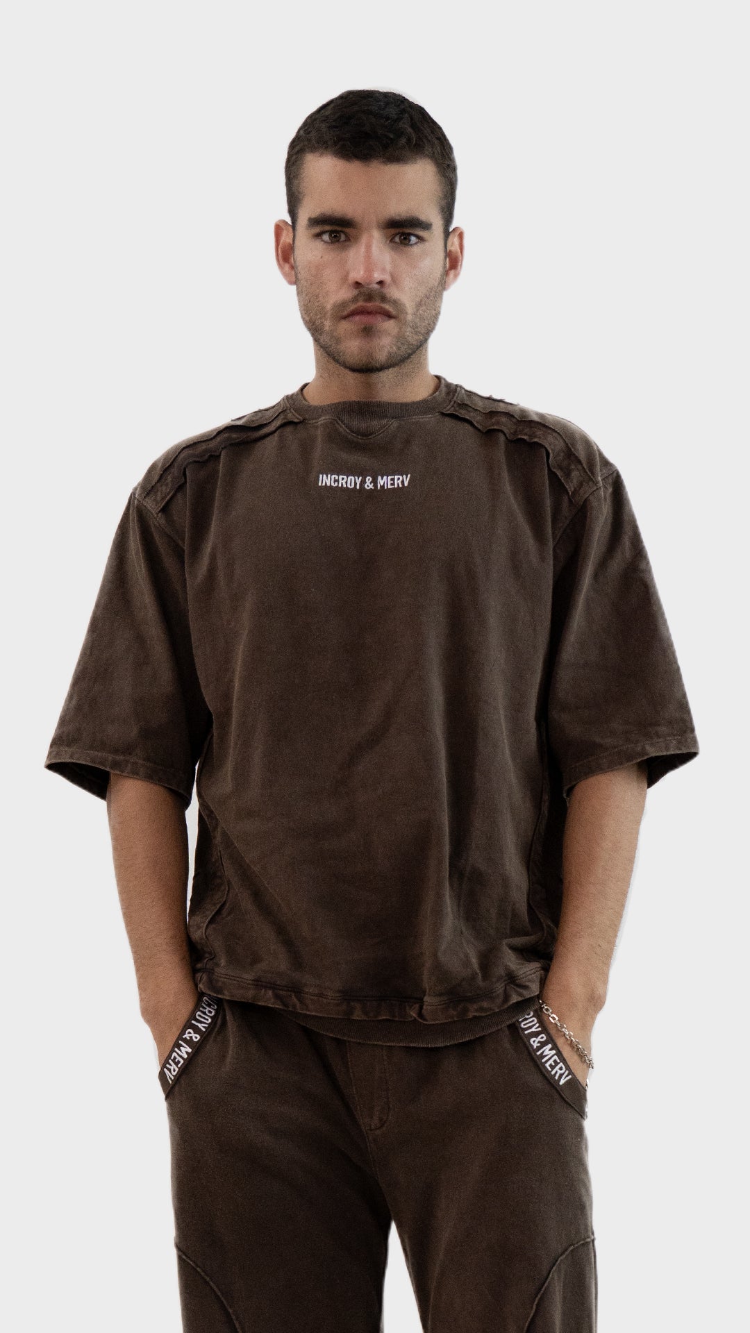 Front view of a man wearing the Incroy and Merv Beyond T-Shirt in Rustic Brown featuring an oversized fit and chest logo.