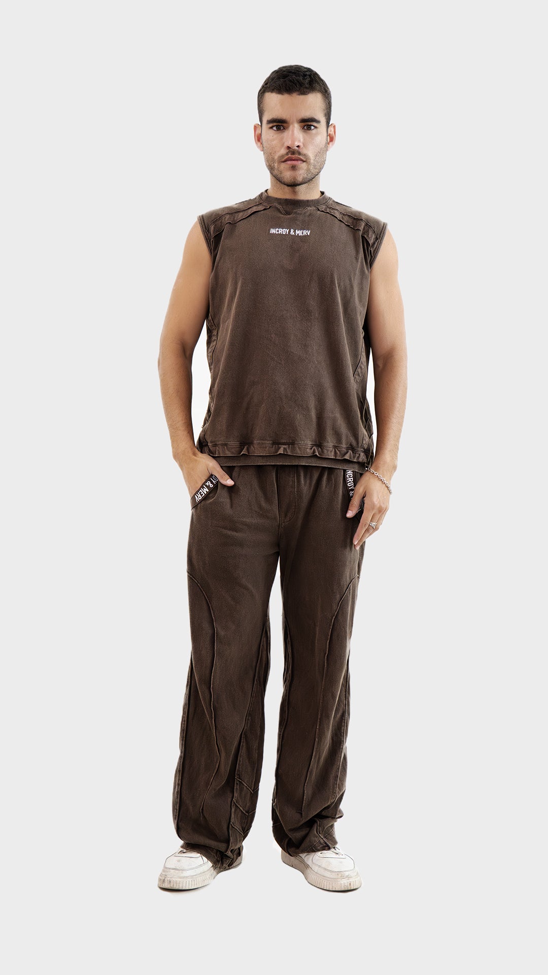 Front view of a man wearing the Incroy and Merv Beyond Tank Top Co-Ord Set in Brown featuring a sleeveless top and matching trousers.