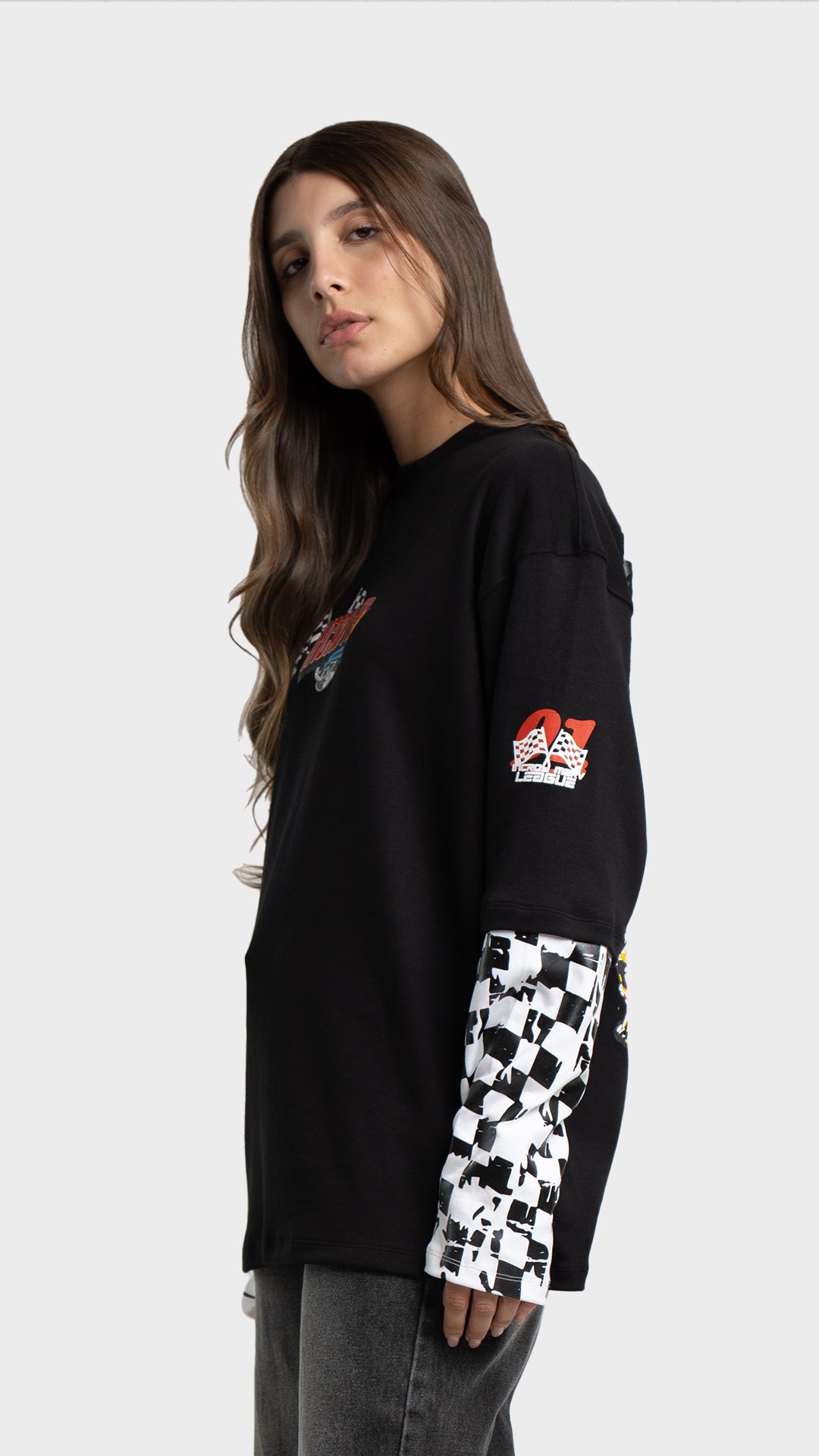 Profile angle of a black long sleeve racing t-shirt by Incroy & Merv with checkered pattern sleeves.