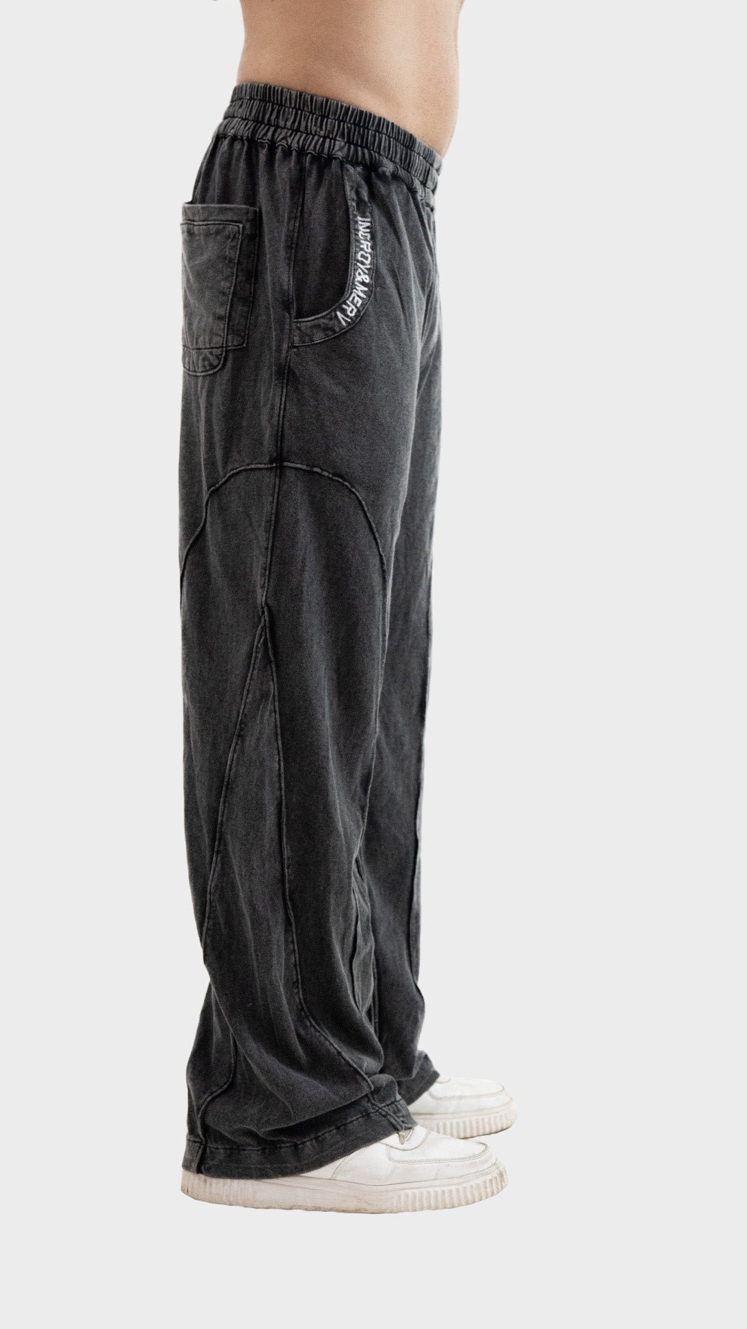 Side profile view showing the relaxed straight-leg fit and raw edge seam structure of Incroy & Merv men's charcoal Beyond Trouser.