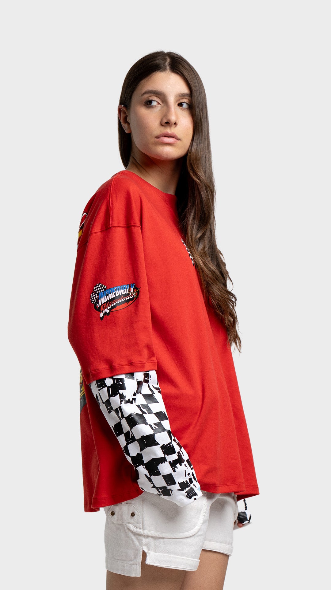 Side view of Incroy & Merv red oversized racing graphic tee paired with white shorts.
