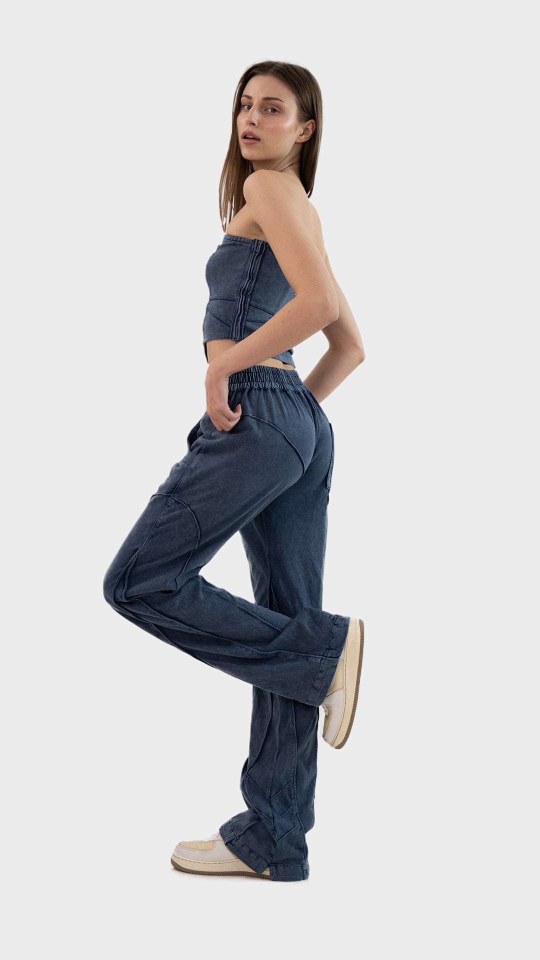 Side view of a woman posing in the dusky blue Beyond Co-Ord Set showing fit of tube top and matching relaxed trousers.