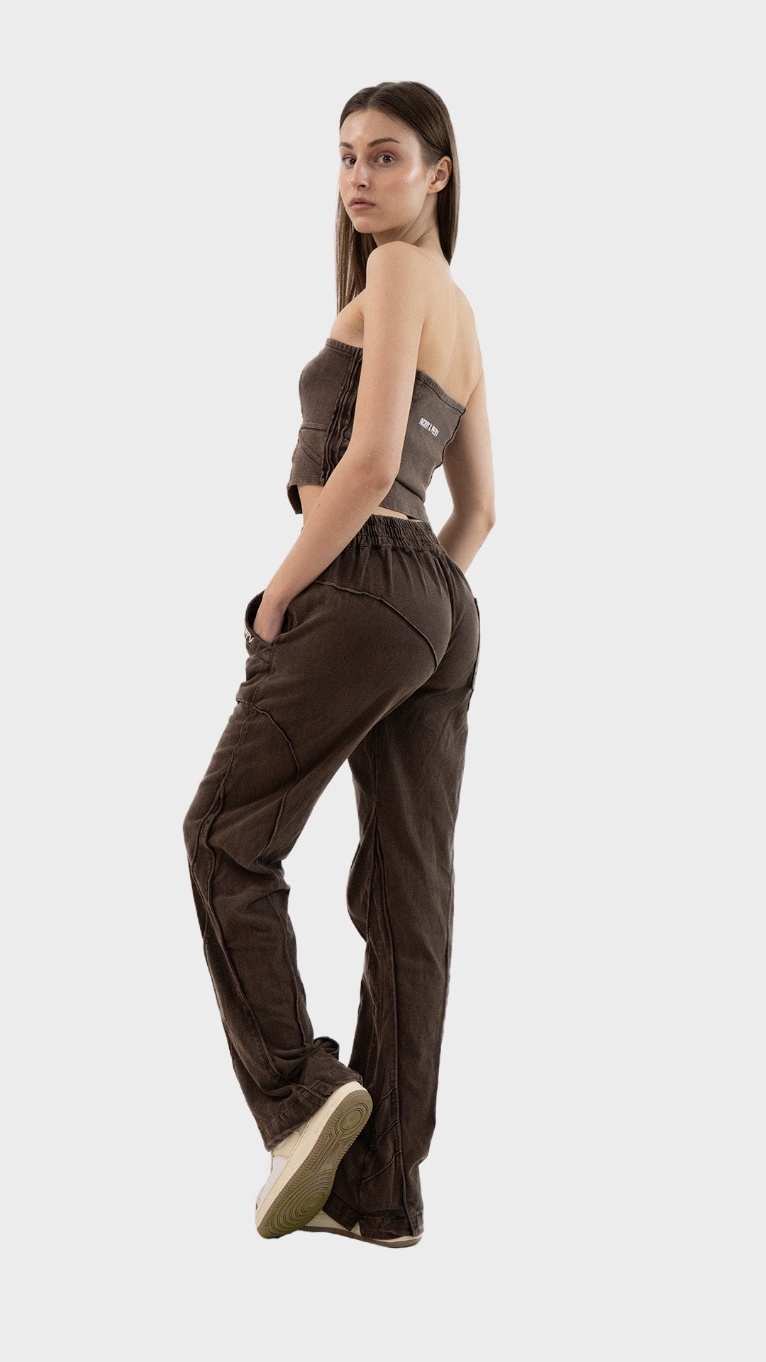 Side view pose of a model wearing the Incroy & Merv washed brown Beyond Co-Ord Set with hands in pockets.