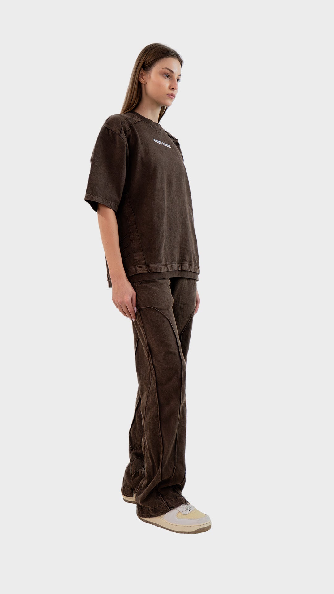 Three-quarter side angle view of Incroy & Merv women's brown Beyond Lower showing pocket embroidery and paneling. 