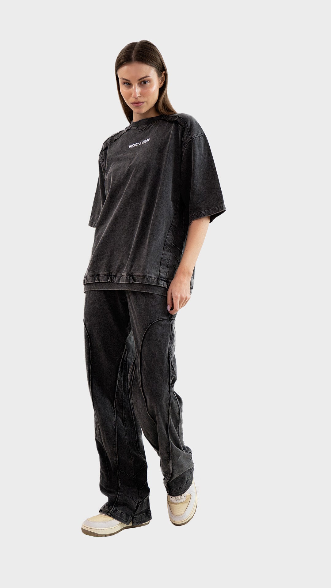 Three-quarter front view of female model wearing Incroy & Merv women's charcoal Beyond Lower showing side pocket detailing.