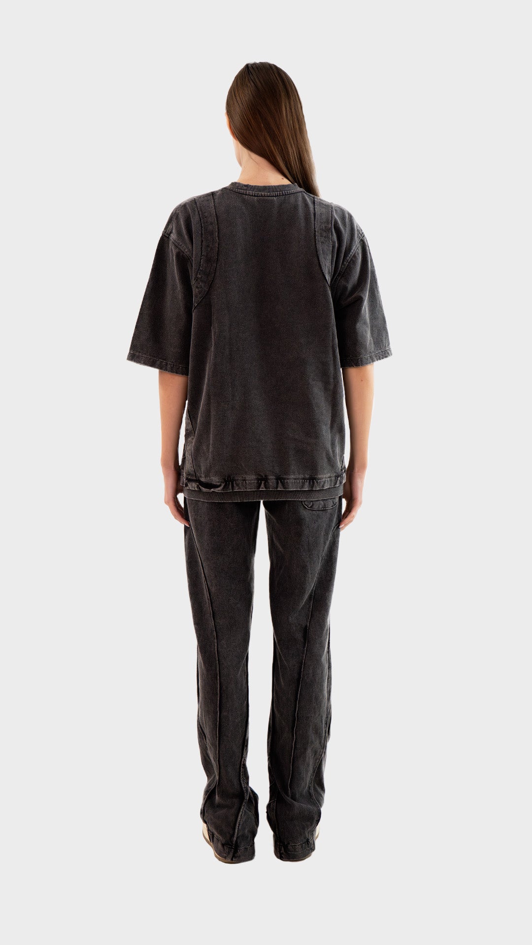 Full length back view of female model wearing Incroy & Merv women's charcoal Beyond Lower displaying rear seam paneling.
