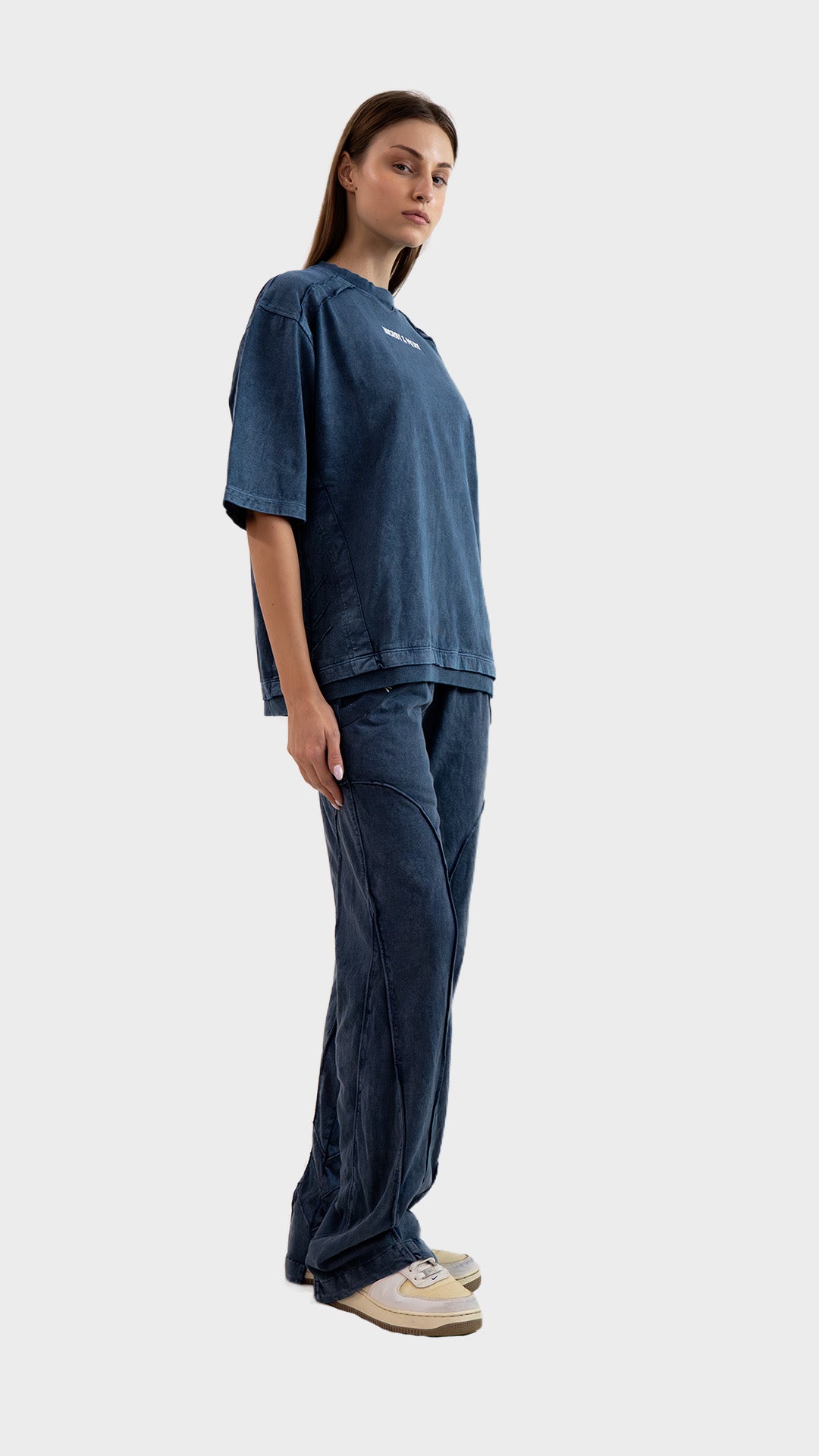 Side profile view showing the relaxed straight fit and raw seam construction of Incroy & Merv women's dusky blue lower.