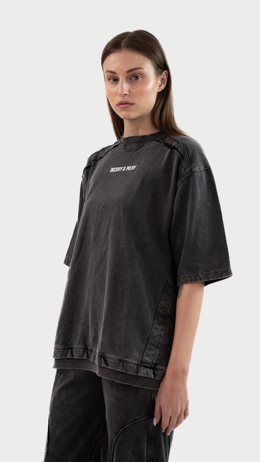 Three-quarter front angle view of a model posing in the charcoal Beyond T-Shirt in cotton sinker fabric.