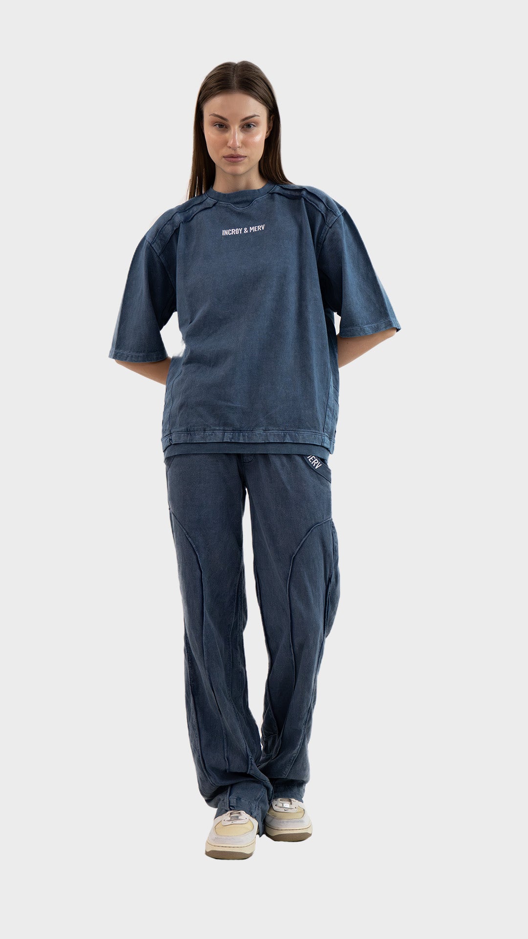 Full body view of a woman wearing the Incroy & Merv Beyond T-Shirt styled with matching dusky blue cotton sinker track pants.