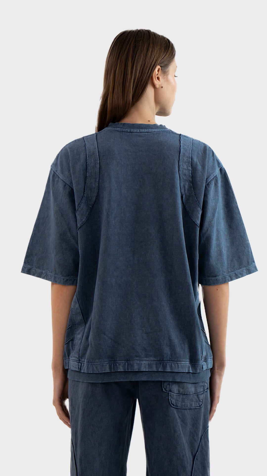 Back view of Incroy & Merv women's Beyond T-Shirt in dusky blue showing exposed seam details and relaxed fit.