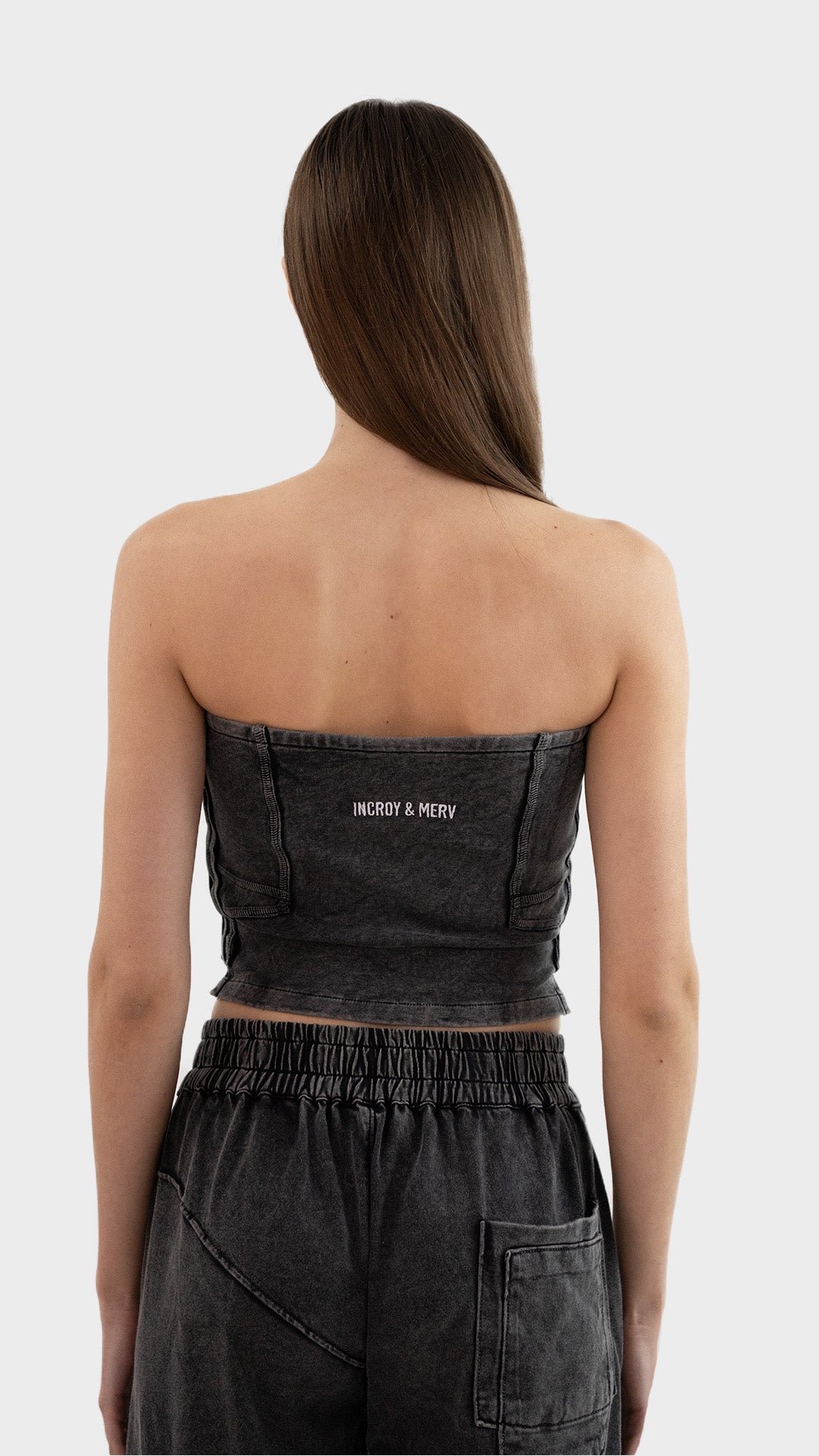 Back view of Incroy & Merv women's Beyond Tube Top in charcoal ribbed fabric showing embroidered logo.