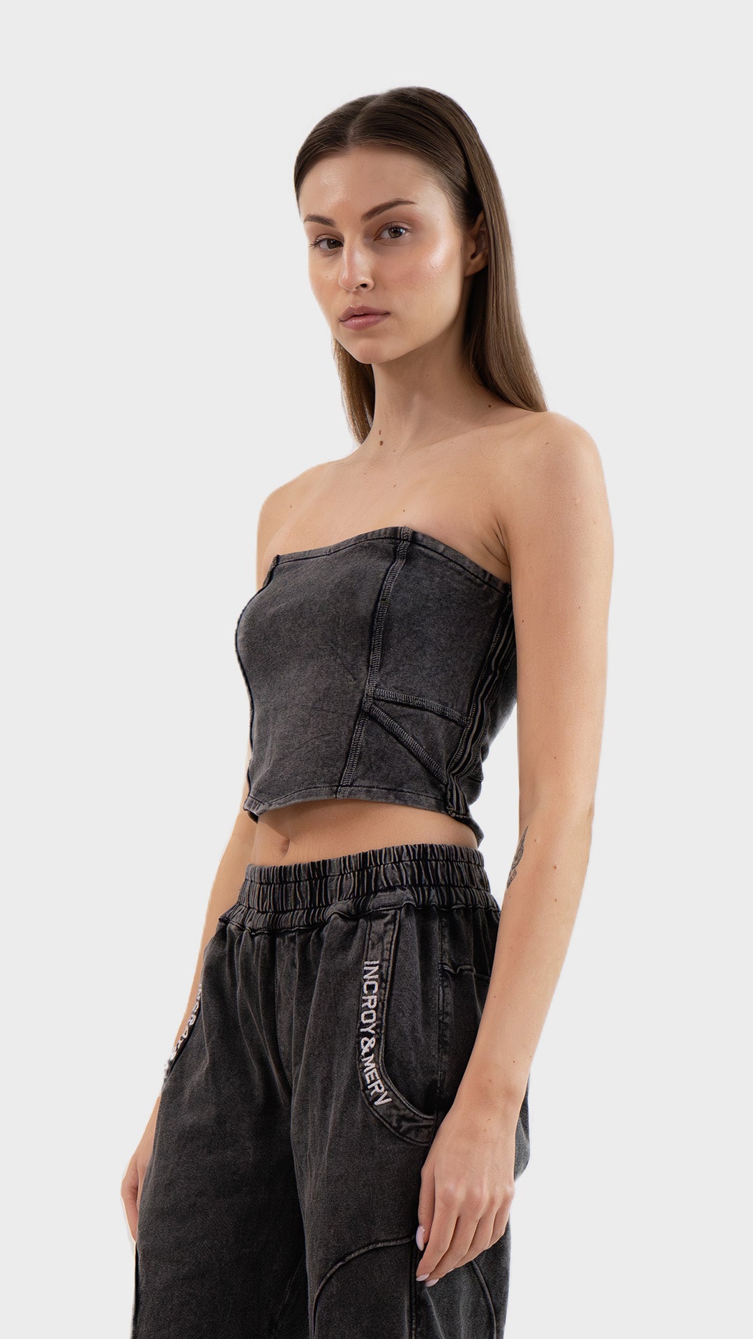 Side profile view showing the fitted shape and ribbed texture of the Incroy & Merv women's charcoal Beyond Tube Top.