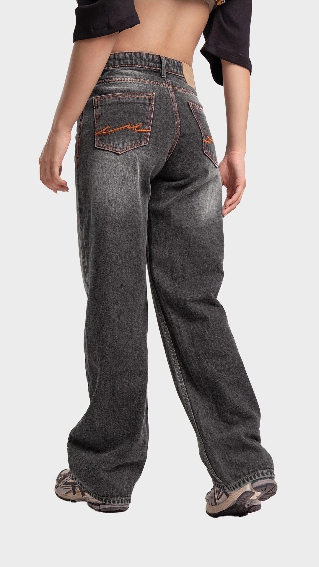 Back pockets and fit perspective of Incroy & Merv women's relaxed fit streetwear jeans in smoked grey.