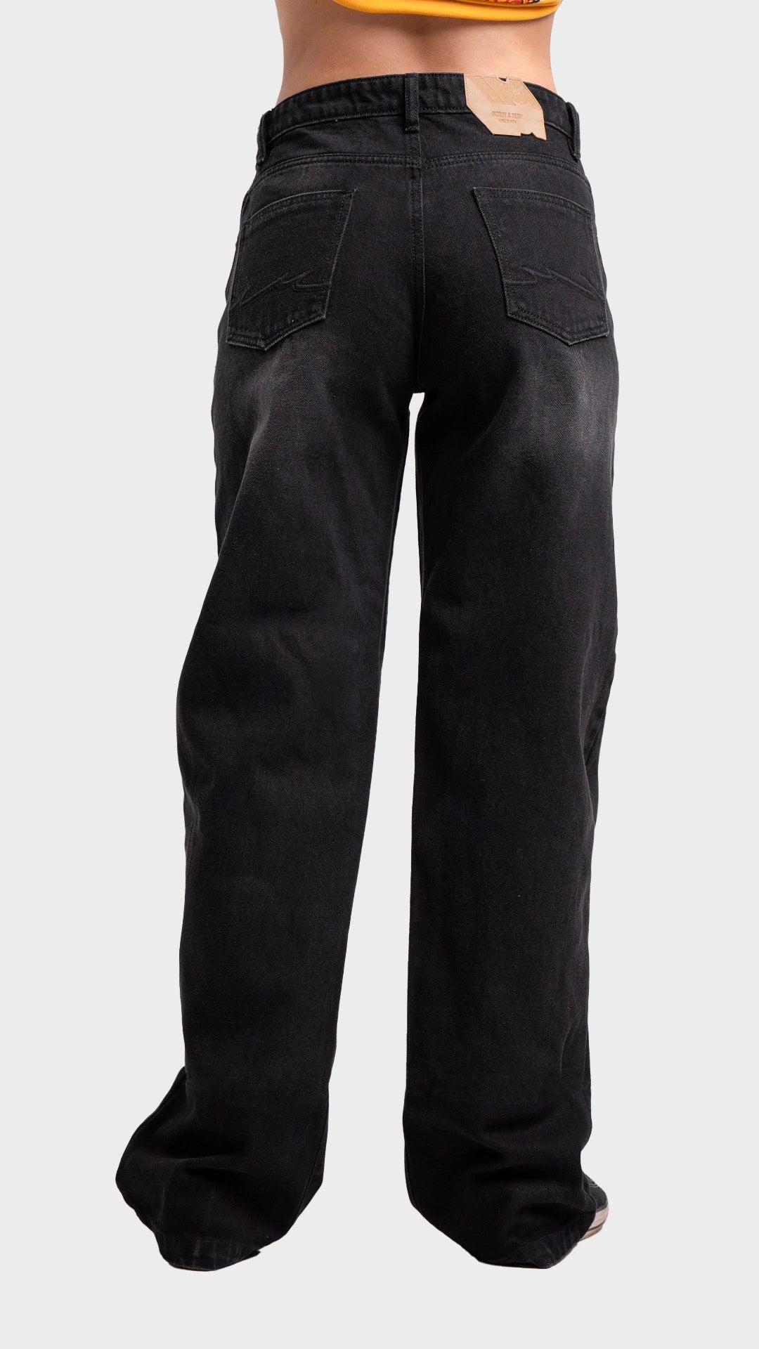 Three-quarter back angle view of women's wide leg drift black denim jeans by Incroy & Merv.