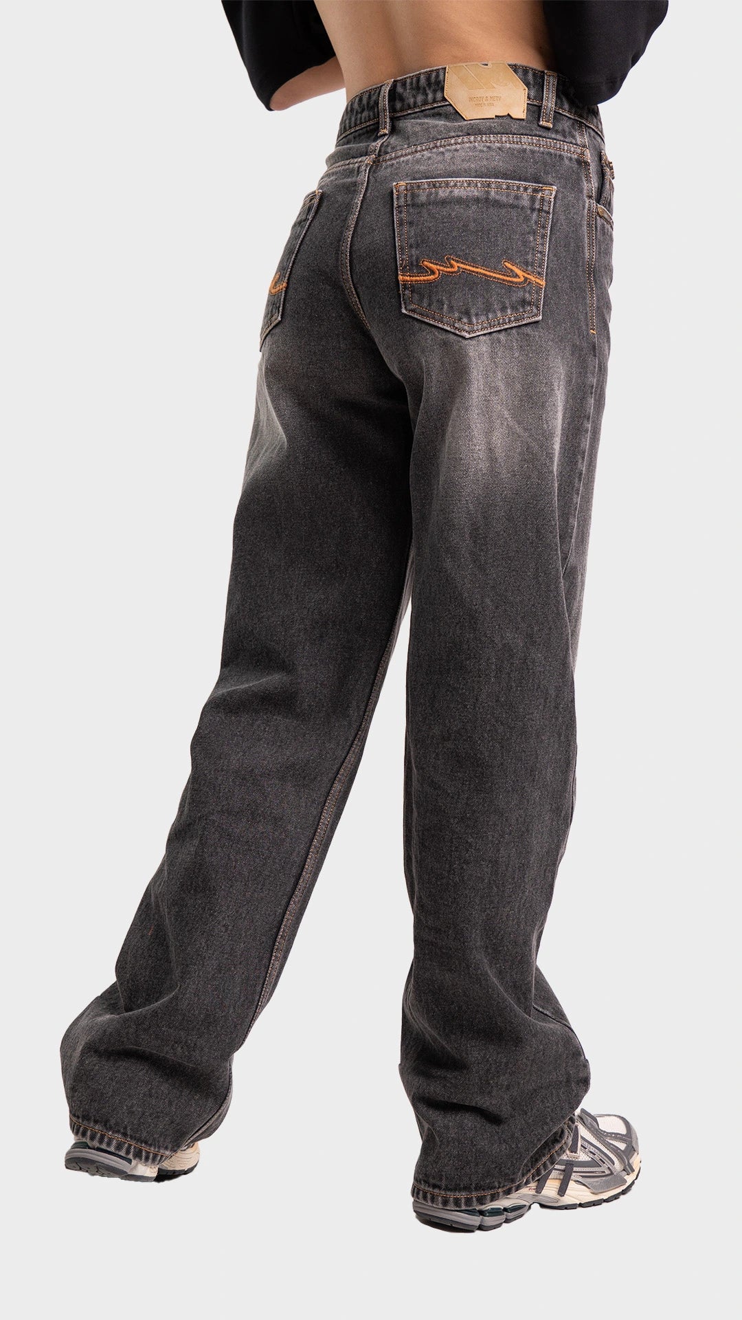 Three-quarter back angle view of women's wide leg smoked grey denim jeans by Incroy & Merv.
