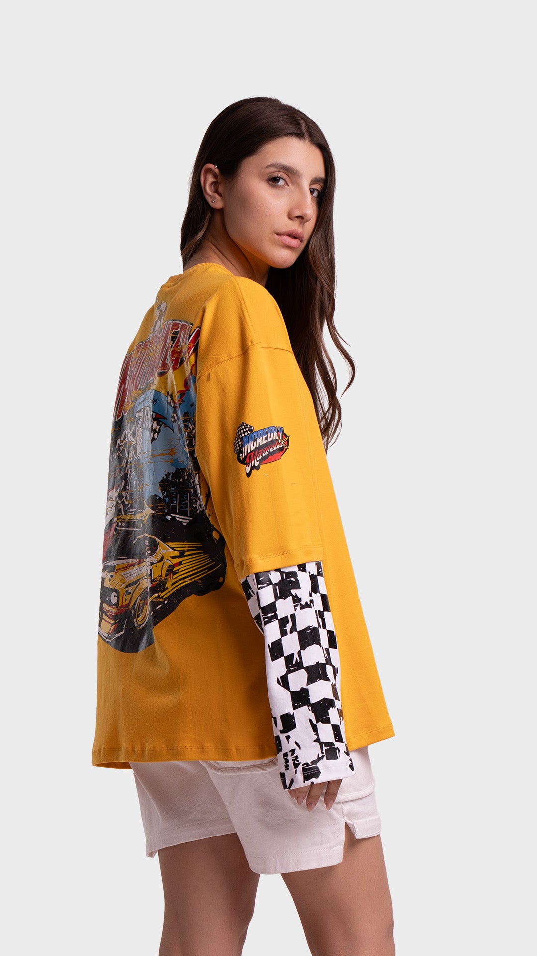 Profile angle of a yellow long sleeve racing t-shirt by Incroy & Merv with checkered pattern sleeves.