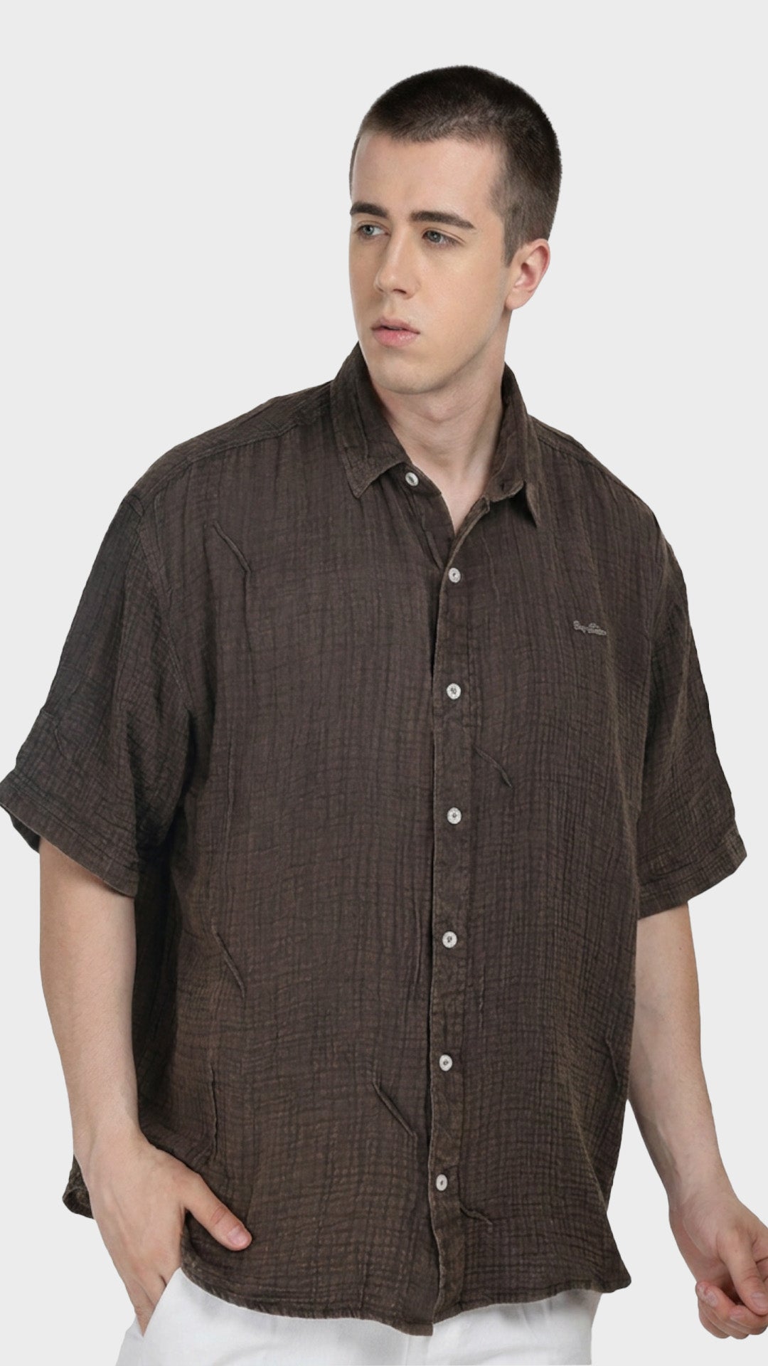 Side front profile of a male model in a dark brown double cloth cotton casual shirt.
