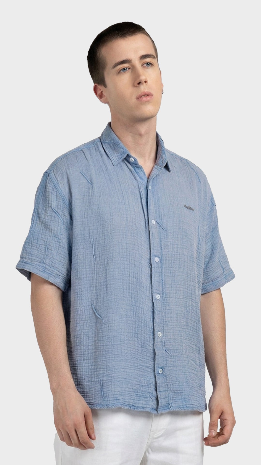 Three-quarter front view of a relaxed fit men's light blue cotton double cloth shirt.