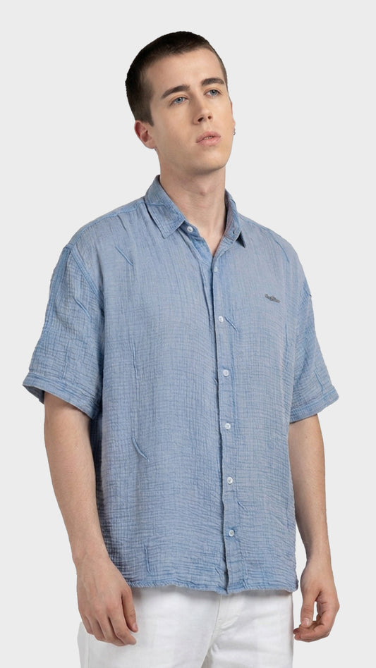 Three-quarter front view of a relaxed fit men's light blue cotton double cloth shirt.