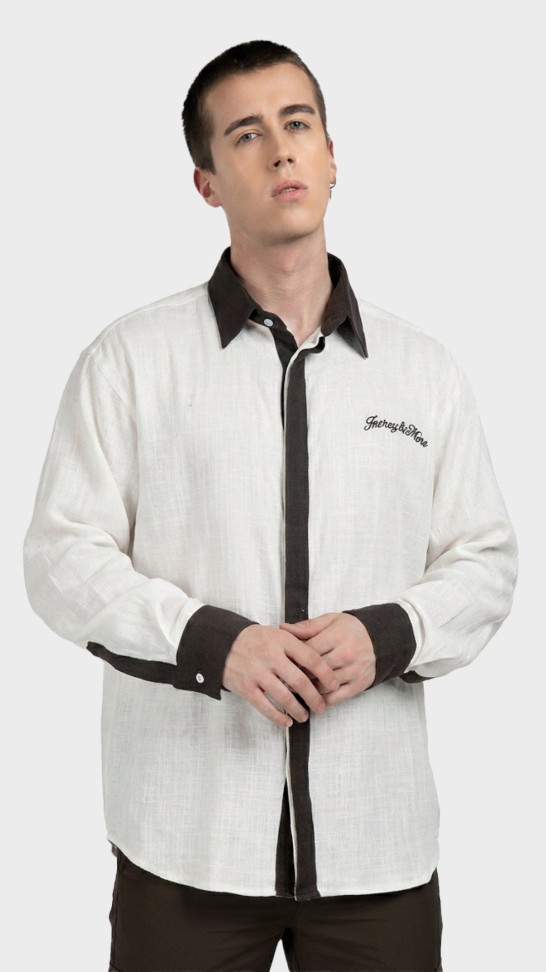 Front view of a male model in a white textured slub fabric shirt with brown trim.