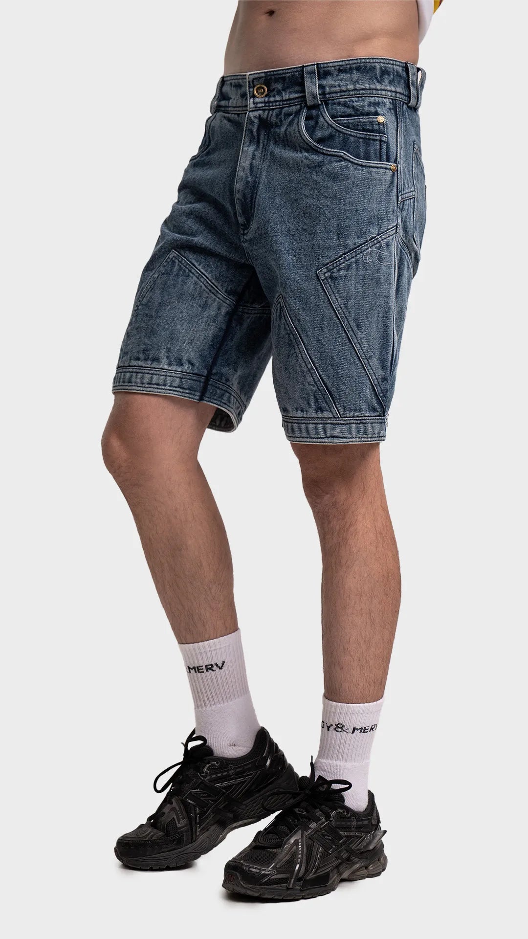 Side profile of men's streetwear blue acid wash denim shorts.