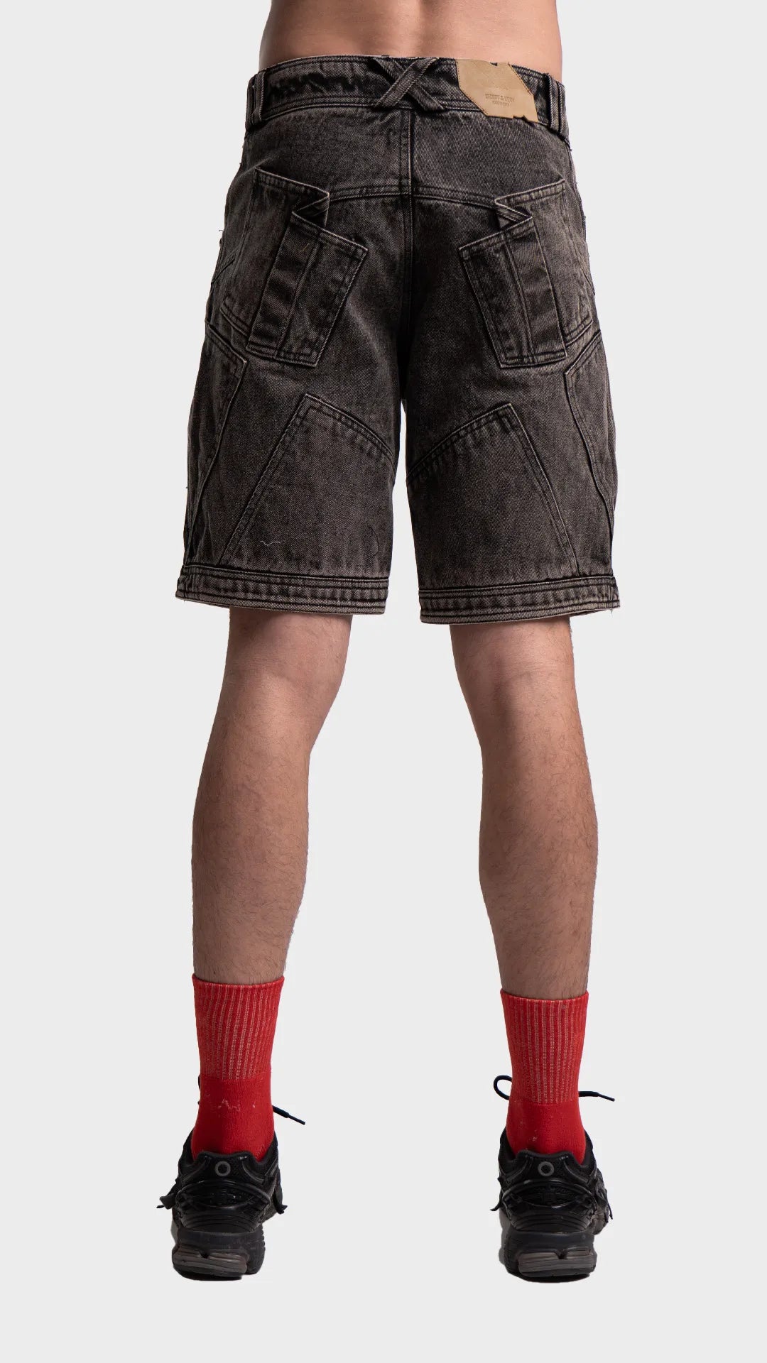 Full back view of men's streetwear black acid wash denim shorts.