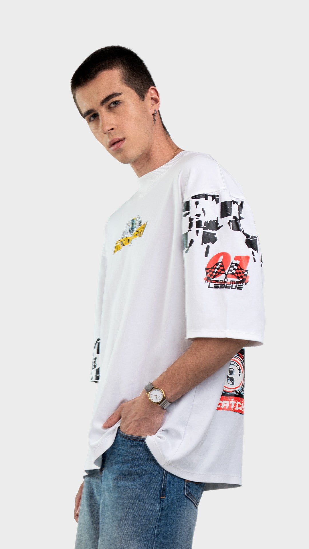 Oversized graphic t-shirt in white. Side profile view of relaxed fit streetwear tee styled with light wash blue jeans.