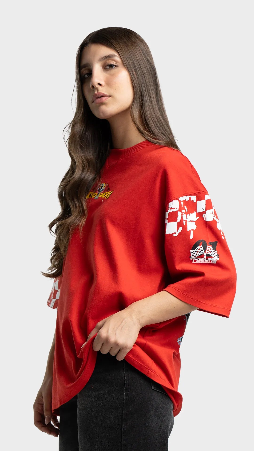 Oversized graphic t-shirt in red. Side view showing vintage racing graphic elements on the sleeves.