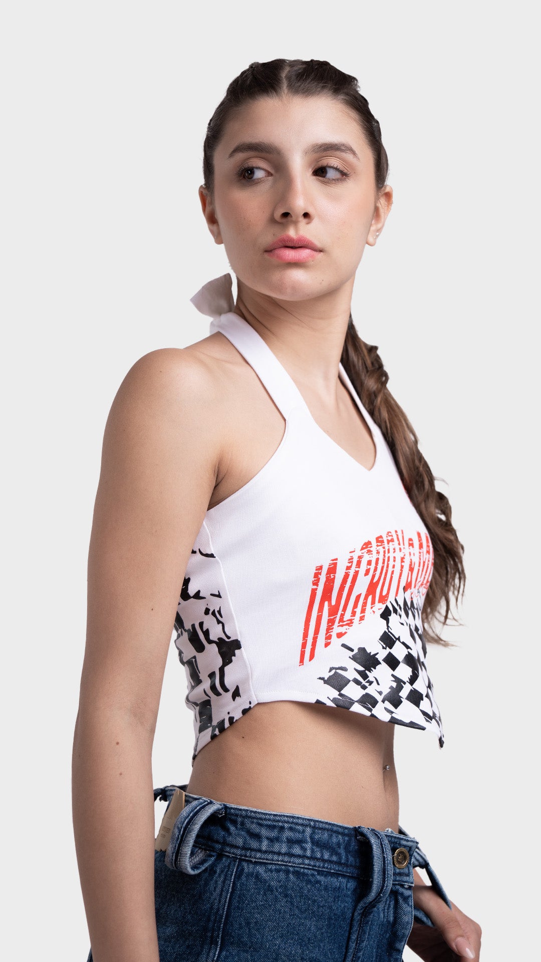 Cropped fit profile of a white graphic halter top in a streetwear style.