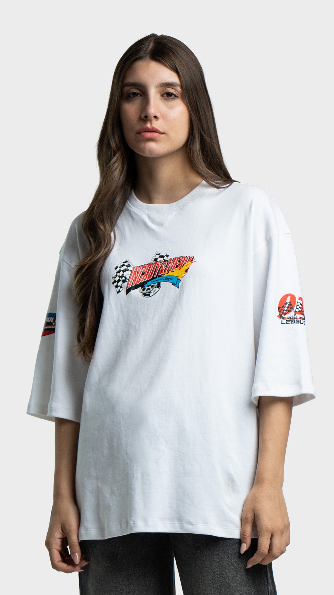 Woman wearing a white oversized streetwear t-shirt with a small retro chest graphic.