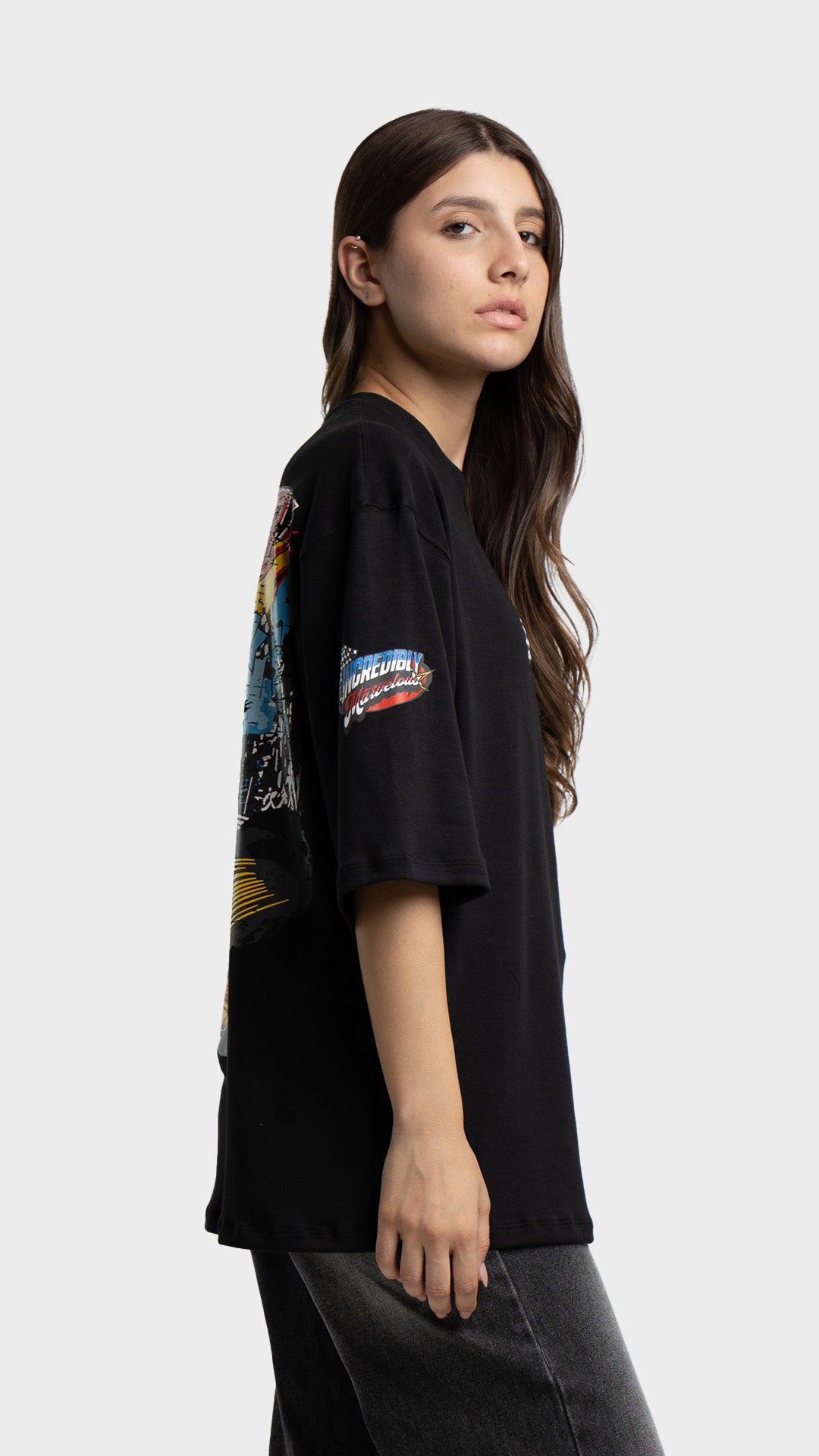 Side profile view of a model posing in a black oversized racing graphic t-shirt