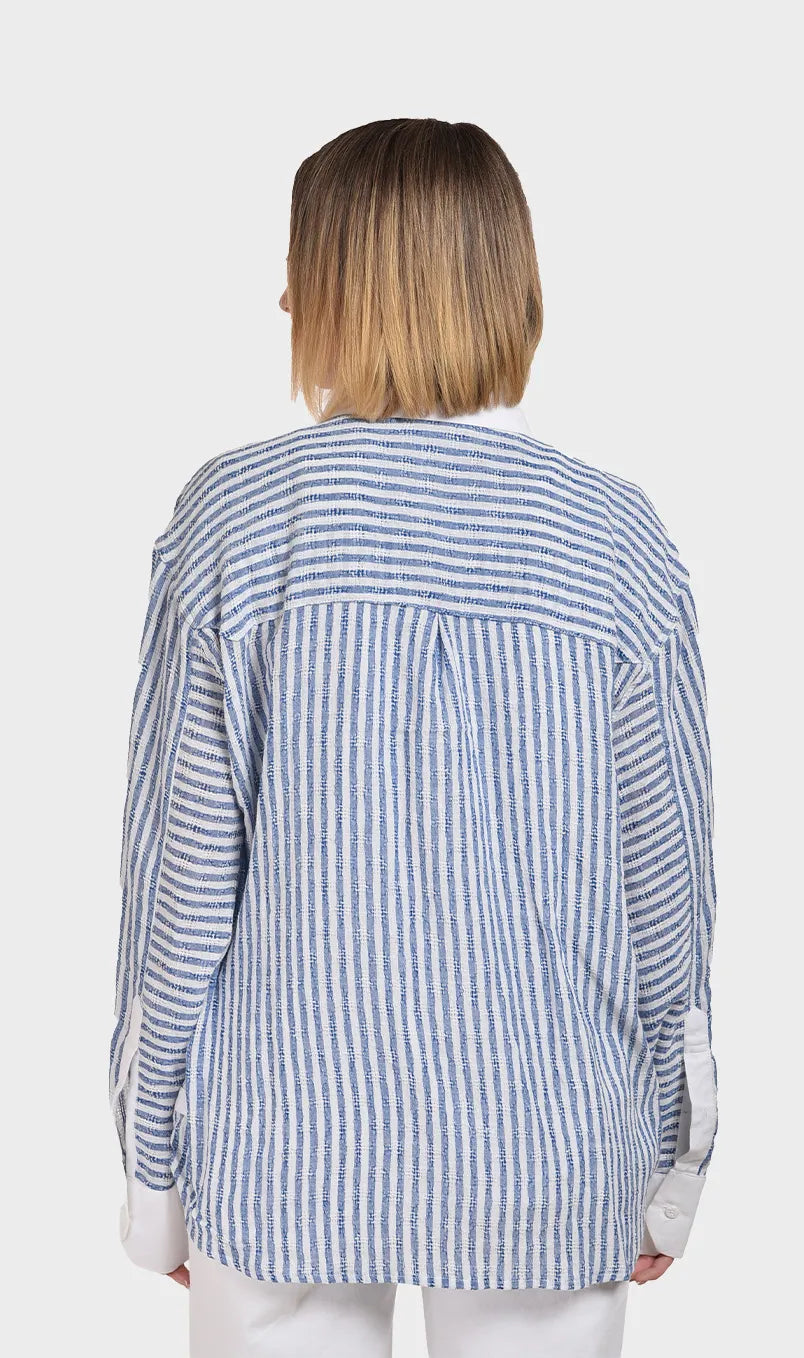 Direct back view showing the relaxed oversized fit and back pleat detail of a women's blue and white striped dobby fabric shirt.