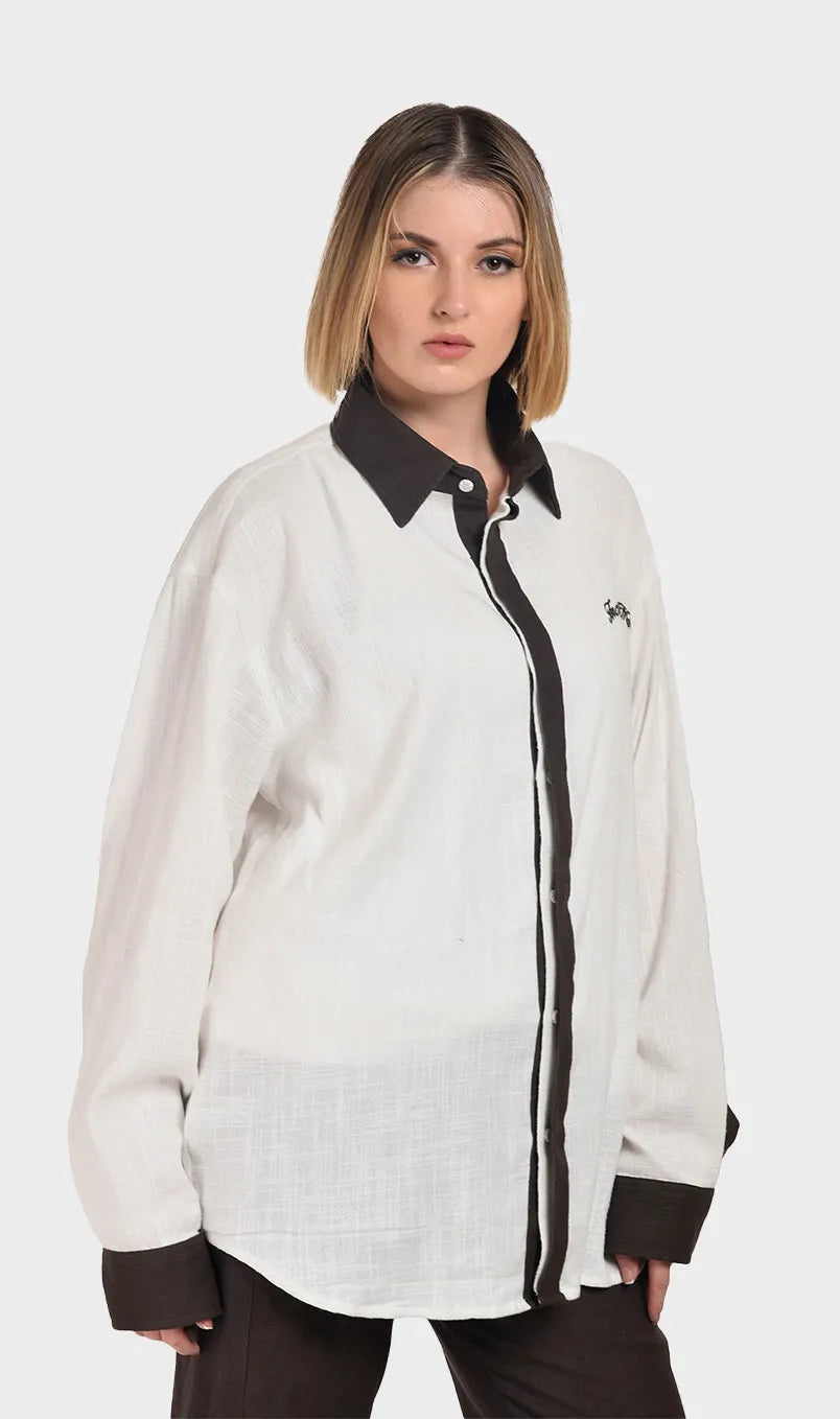 Front profile of a model wearing a textured cream slub fabric shirt with a dark brown contrast collar.